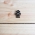 Black HappyBot badge against a wooden background
